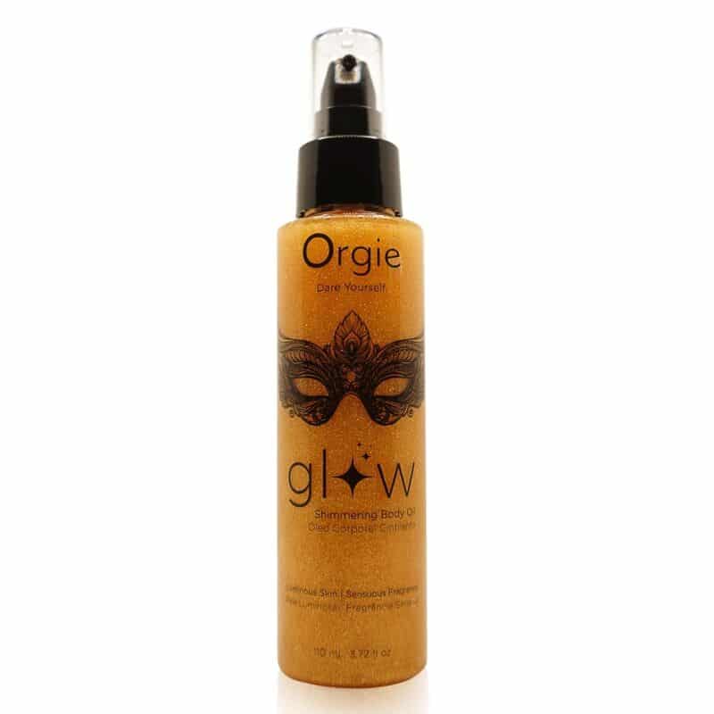 Botella pulverizadora de aceite corporal iluminador Orgie Glow, con envase dorado y dibujo de una máscara