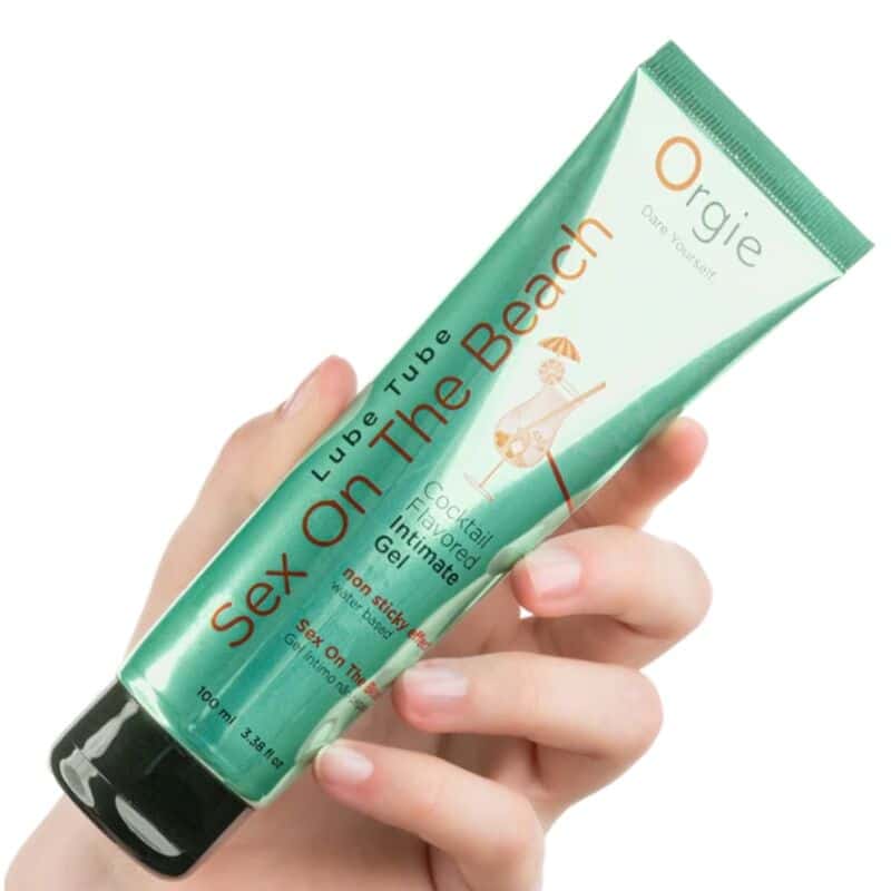 Tubo verde ORGIE Sex On The Beach de gel íntimo, sostenido en una mano